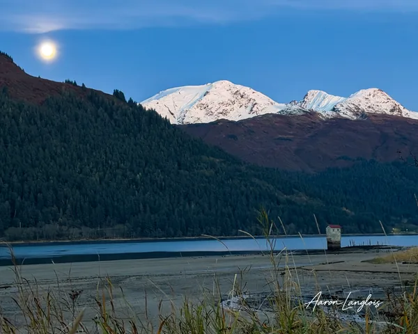 Full moon above snowy peaks viewed from Sandy Beach