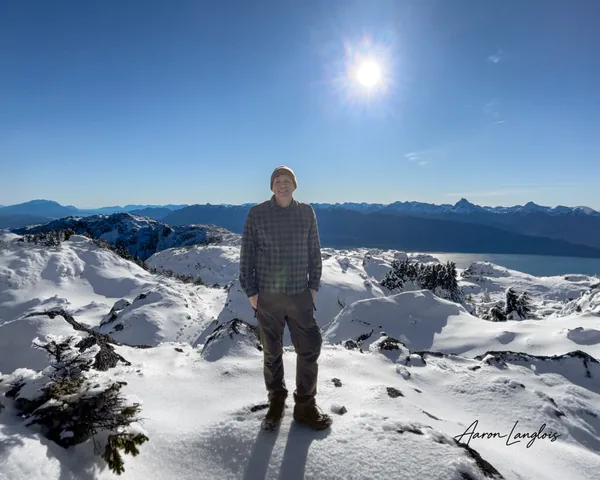 Aaron standing on the snowy summit of Mount Jumbo